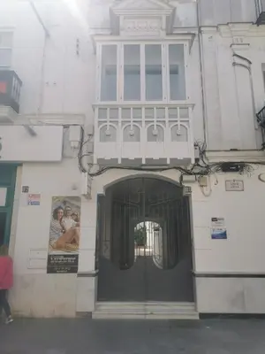 a building with a door with a balcony on it at Buhardilla en calle Ancha, pleno centro in Sanlúcar de Barrameda
