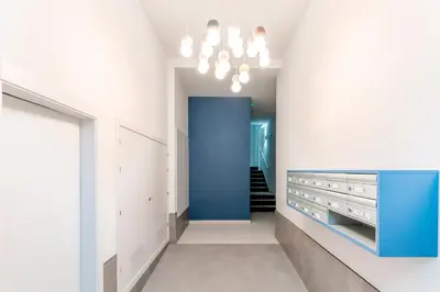 a hallway with white walls and a blue cabinet at Genteel Home Sagasta in Cádiz