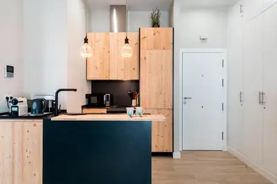 a kitchen with a blue counter top and wooden cabinets at Genteel Home Sagasta in Cádiz