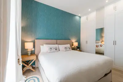a bedroom with a white bed and a blue wall at Genteel Home Sagasta in Cádiz