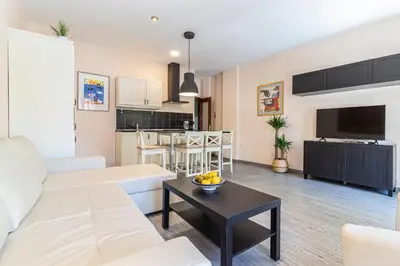 a living room with a white couch and a table at Allo Apartments Plateros II Centro 2 Habitaciones in Jerez de la Frontera