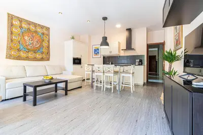 a living room and kitchen with a couch and a table at Allo Apartments Plateros II Centro 2 Habitaciones in Jerez de la Frontera