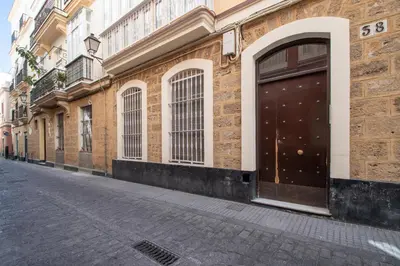 a brick building with a large door on a street at Apartamento Ooh La Lá Cádiz in Cádiz