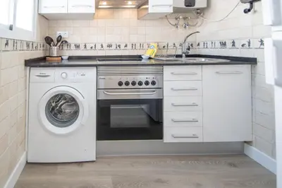 a kitchen with a stove and a washing machine at Apartamento Ooh La Lá Cádiz in Cádiz