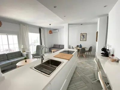 a white kitchen and living room with a sink at Apartamento en calle Ancha, en pleno centro in Sanlúcar de Barrameda