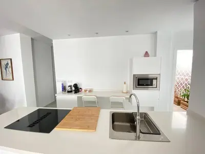 a white kitchen with a sink and a counter top at Apartamento en calle Ancha, en pleno centro in Sanlúcar de Barrameda