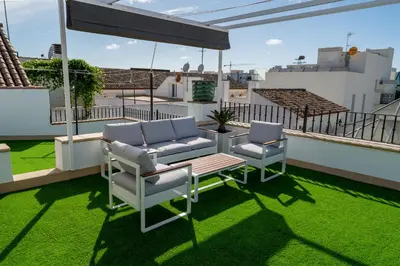 a patio with two chairs and a table on a roof at Cabildo Spa 1 in Sanlúcar de Barrameda