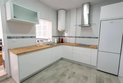 a white kitchen with white cabinets and a sink at Cabildo Spa 1 in Sanlúcar de Barrameda