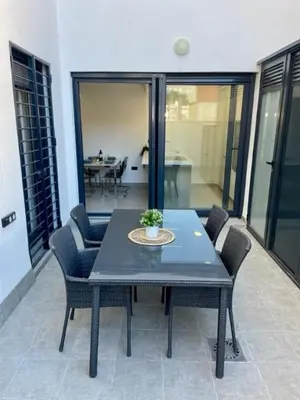 a table and chairs in a room with a balcony at GATU PREMIUM Alma marinera, Preferente mayores de 21 años y familias in Cádiz