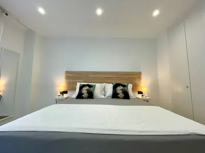a bedroom with a large white bed with two dogs on the pillows at GATU PREMIUM Alma marinera, Preferente mayores de 21 años y familias in Cádiz