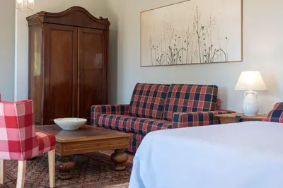 a hotel room with a bed and two chairs at Cortijo La Mina by LaJudería de Vejer - Luxury Villa in Conil de la Frontera