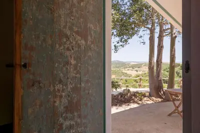 an open door with a view of a patio with trees at Cortijo La Mina by LaJudería de Vejer - Luxury Villa in Conil de la Frontera