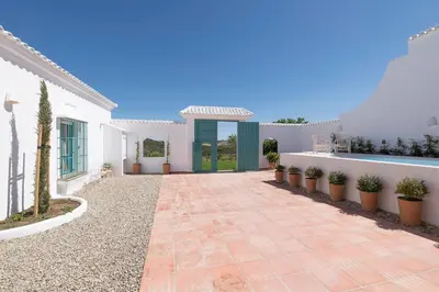 a courtyard of a white house with potted plants at Cortijo La Mina by LaJudería de Vejer - Luxury Villa in Conil de la Frontera