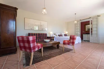 a bedroom with a bed and two chairs and a table at Cortijo La Mina by LaJudería de Vejer - Luxury Villa in Conil de la Frontera
