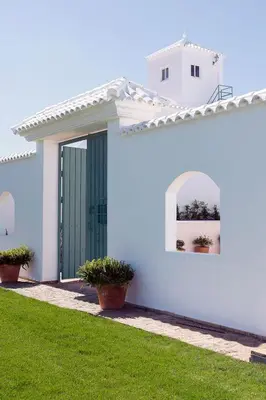 a white house with a green door and a yard at Cortijo La Mina by LaJudería de Vejer - Luxury Villa in Conil de la Frontera