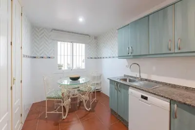 a kitchen with blue cabinets and a table with chairs at Costa Ballena Unifamiliar in Costa Ballena