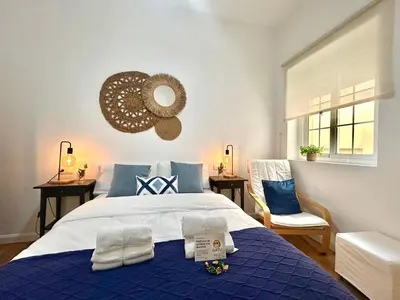 a bedroom with a blue and white bed and a window at GATU Ringo in El Puerto de Santa María