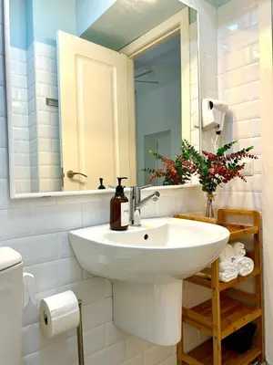 a bathroom with a white sink and a mirror at GATU Ringo in El Puerto de Santa María
