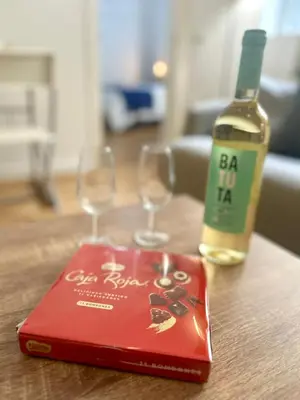 a bottle of wine and two wine glasses on a table at GATU Ringo in El Puerto de Santa María