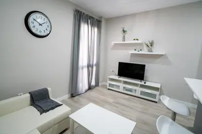 a living room with a couch and a clock on the wall at Apartamento Cabildo Spa 2 in Sanlúcar de Barrameda