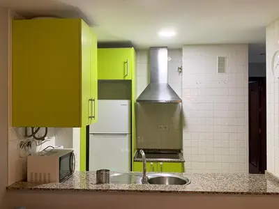 a kitchen with green cabinets and a sink at Apartamento a 5 minutos de la playa de la caleta in Cádiz