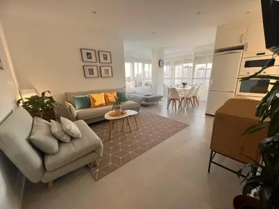 a living room with a couch and a table at GATU Villa Soleá parking, piscina, pistas tenis, playa de Valdelagrana in El Puerto de Santa María