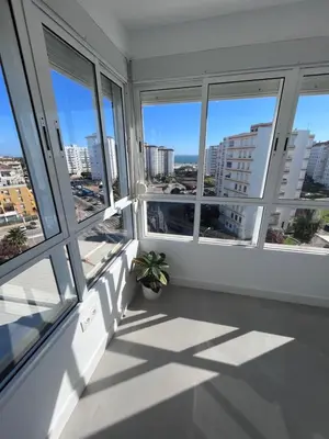 a room with windows and a potted plant at GATU Villa Soleá parking, piscina, pistas tenis, playa de Valdelagrana in El Puerto de Santa María