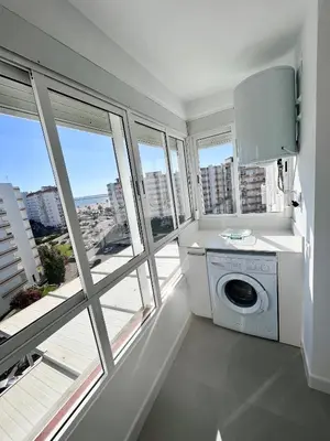 a washing machine in a laundry room with windows at GATU Villa Soleá parking, piscina, pistas tenis, playa de Valdelagrana in El Puerto de Santa María