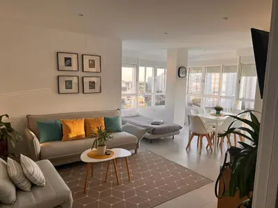 a living room with a couch and a table at GATU Villa Soleá parking, piscina, pistas tenis, playa de Valdelagrana in El Puerto de Santa María