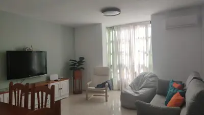 a living room with a couch and a flat screen tv at Apartamento Tres Carabelas, AC, Wifi, Parking in Sanlúcar de Barrameda