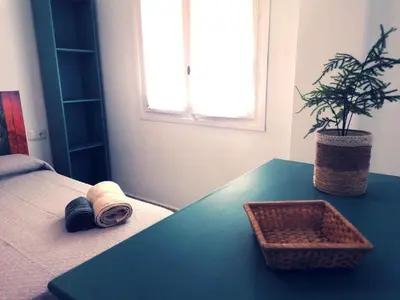 a bedroom with a table with a plant on it at Apartamento Tres Carabelas, AC, Wifi, Parking in Sanlúcar de Barrameda