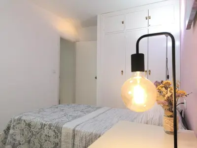 a room with a bed and a lamp on a table at Apartamento Tres Carabelas, AC, Wifi, Parking in Sanlúcar de Barrameda
