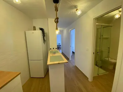 a kitchen with a white refrigerator in a room at Apartamento Trascuesta, PLENO CENTRO in Sanlúcar de Barrameda