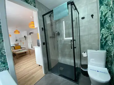 a bathroom with a toilet and a glass shower at Apartamento Trascuesta, PLENO CENTRO in Sanlúcar de Barrameda