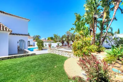 a backyard with a lawn and a pool at Villa Mas Tranquila - A stylish villa with pool 150 m from the beach in Conil de la Frontera