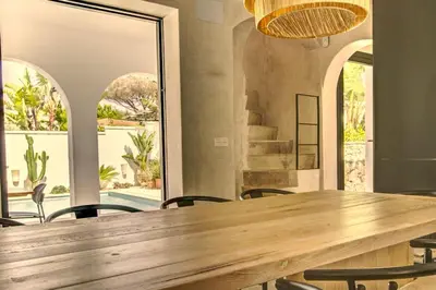 a large wooden table in a room with chairs at Villa Mas Tranquila - A stylish villa with pool 150 m from the beach in Conil de la Frontera