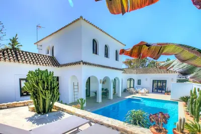 a villa with a swimming pool and a house at Villa Mas Tranquila - A stylish villa with pool 150 m from the beach in Conil de la Frontera