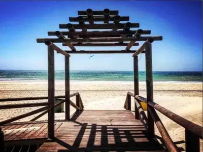 a wooden boardwalk on a beach with the ocean at Beautiful apartment in San Fernando near lake in San Fernando
