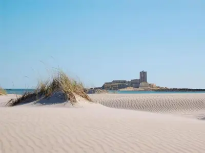a pile of sand on a beach with a castle in the background at Beautiful apartment in San Fernando near lake in San Fernando
