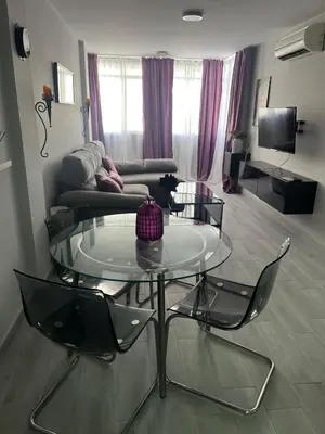 a living room with a glass table and two chairs at Piso Centro La Morena, Climatizado, Wifi in Sanlúcar de Barrameda