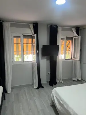 a bedroom with a bed and a flat screen tv at Piso Centro La Morena, Climatizado, Wifi in Sanlúcar de Barrameda