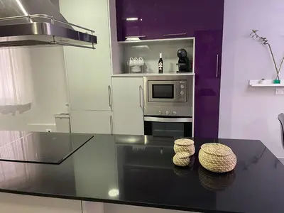 a kitchen with a glass table and a microwave at Piso Centro La Morena, Climatizado, Wifi in Sanlúcar de Barrameda