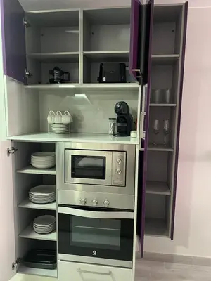 a kitchen with a stove and a microwave at Piso Centro La Morena, Climatizado, Wifi in Sanlúcar de Barrameda