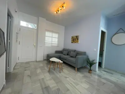 a living room with a couch and a table at El Sabor del Sur, Apartamentos Living Sur in Sanlúcar de Barrameda