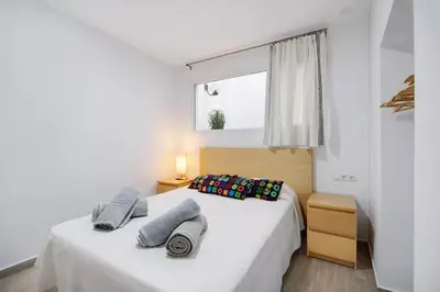 a bedroom with a bed with two pillows and a window at Precioso alojamiento con patio interior in Cádiz