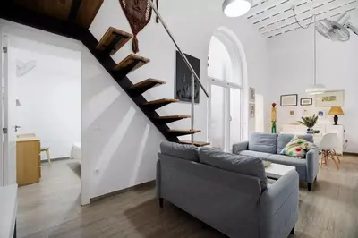 a living room with a staircase and a couch at Precioso alojamiento con patio interior in Cádiz