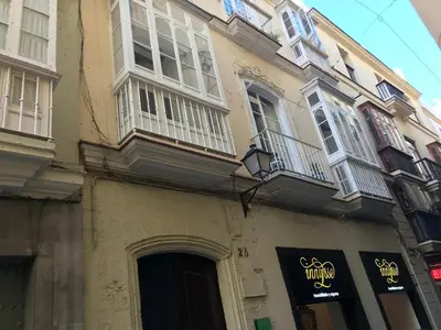 a building with a sign on the side of it at Precioso alojamiento con patio interior in Cádiz