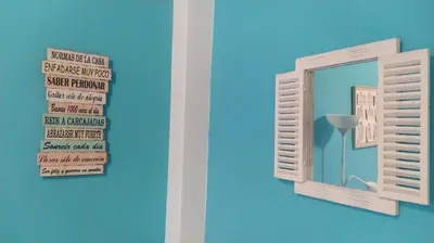 a mirror on a blue wall with a window at El Ancla in Chiclana de la Frontera