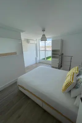 a large white bedroom with a large white bed at Atico duplex con Terraza en pleno centro de Jerez in Jerez de la Frontera