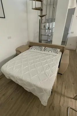 a bedroom with a bed with a white comforter at Atico duplex con Terraza en pleno centro de Jerez in Jerez de la Frontera